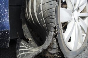A damaged car tire after a blowout.